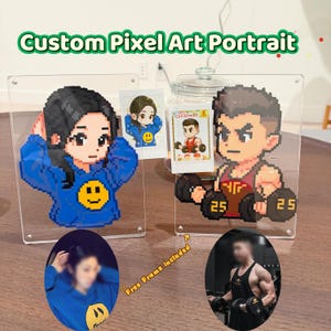 May include: Custom pixel art portraits displayed in clear acrylic frames. One features a woman in a blue hoodie, the other a man lifting weights. Small photo prints are also included. The text "Custom Pixel Art Portrait" is at the top.