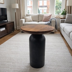 May include: A contemporary side table featuring a dark brown, circular wooden top and a black, cylindrical base. The table is suitable for a living room. The table's diameter is approximately 50 cm and its height is about 61 cm.