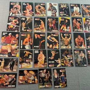 May include: A collection of thirty-five rectangular WCW Main Event wrestling trading cards featuring various professional wrestlers in action poses, ring entrances, and portraits, each card displaying the WCW Main Event logo in the corner.