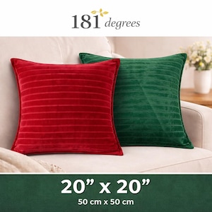 May include: Two decorative throw pillows, one red and one green, rest on a cream-colored sofa. The red pillow has horizontal lines, and the green pillow has vertical lines. The pillows are 20" x 20". The brand name "181 degrees" is at the top.