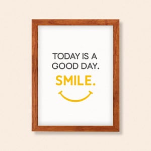 May include: A framed print with the words "TODAY IS A GOOD DAY. SMILE." in gray and yellow. The frame is made of wood with a warm brown finish. The background is a light beige color.