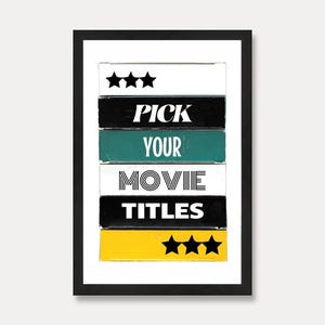 Puede incluir: Impresión artística enmarcada con el texto "PICK YOUR MOVIE TITLES" en un diseño apilado. El diseño presenta bloques negros, blancos, verde azulado y amarillos con iconos de estrellas. La impresión está en un marco negro.