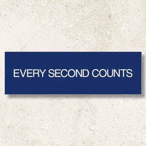 Può includere: Un cartello rettangolare blu navy con il testo bianco EVERY SECOND COUNTS in un carattere pulito e senza grazie. Il cartello è centrato e presenta un design piatto e minimalista con bordi netti, offrendo un impatto visivo chiaro e audace.
