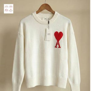 Könnte beinhalten: Ein Set aus drei Keramikbechern mit gesprenkelter, matter Oberfläche. Die Becher sind in Creme-, Hellgrau- und Dunkelgrautönen gehalten. Jeder Becher hat ein schlichtes, minimalistisches Design.