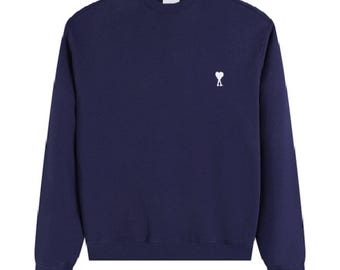 Sudadera clásica de cuello redondo con bordado en forma de corazón de Ami en los hombros y cuello redondo para principios de otoño.