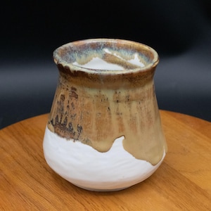 May include: A set of three ceramic mugs with a speckled, matte finish. The mugs are in shades of cream, light gray, and dark gray. Each mug has a simple, modern design and a rounded handle. Perfect for coffee or tea.