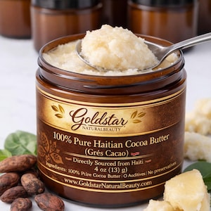 May include: A jar of Goldstar Natural Beauty 100% Pure Haitian Cocoa Butter, with a spoon scooping out the product. The jar is brown with a black lid and a gold label. The label includes the text "Grés Cacao" and "4 oz (13 g)".