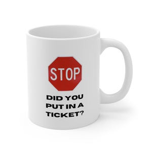 May include: White ceramic mug with a red stop sign graphic and the text "STOP DID YOU PUT IN A TICKET?". The mug has a curved handle and is suitable for hot or cold beverages.