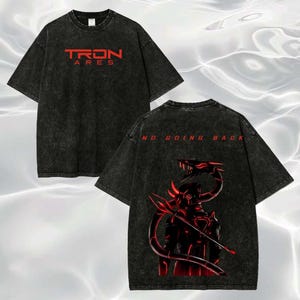 May include: A black acid-wash t-shirt featuring the red text TRON ARES on the front. The back displays a red graphic of a robotic figure with a long tail and the red text NO GOING BACK. The shirt has short sleeves and a crew neckline.