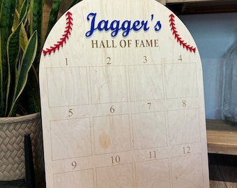 May include: A wooden baseball-shaped sign with the text "Jagger's Hall of Fame" and 12 numbered squares for displaying photos or memorabilia.
