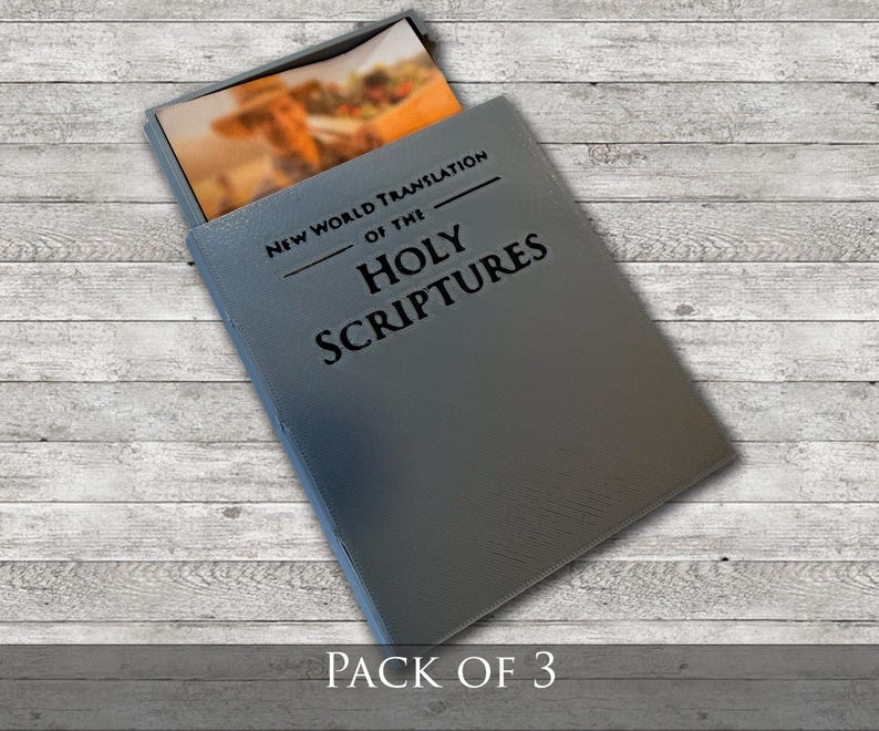 May include: A gray book with the text "NEW WORLD TRANSLATION OF THE HOLY SCRIPTURES" is partially open, revealing a colorful image. The words "PACK OF 3" are printed at the bottom of the image.