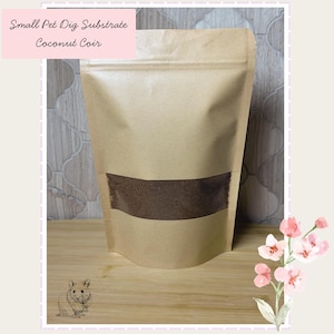 May include: A brown paper stand-up pouch containing coconut coir small pet dig substrate. The packaging features a clear rectangular window revealing the dark brown contents and text that reads Small Pet Dig Substrate Coconut Coir.