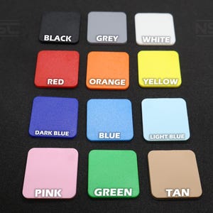Pu&ograve; includere: Una collezione di campioni di colore quadrati in varie tonalit&agrave;, tra cui nero, grigio, bianco, rosso, arancione, giallo, blu scuro, blu, azzurro, rosa, verde e beige. Ogni campione ha il suo nome di colore stampato.