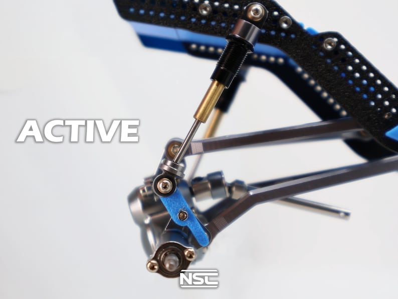 Pu&ograve; includere: Primo piano di un componente meccanico con la scritta "ACTIVE" in bianco. Il componente presenta parti nere, blu e argentate, tra cui un ammortizzatore e vari collegamenti. Il design suggerisce precisione e ingegneria.