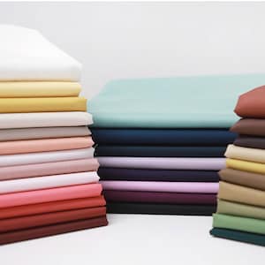 Könnte beinhalten: Ein Stapel Stoffmuster in verschiedenen Farben, darunter Weiß, Gelb, Beige, Rosa, Rot, Braun, Grün, Blau und Lila. Die Stoffmuster sind in einem ordentlichen Stapel angeordnet und zeigen die verschiedenen Farben und Texturen.