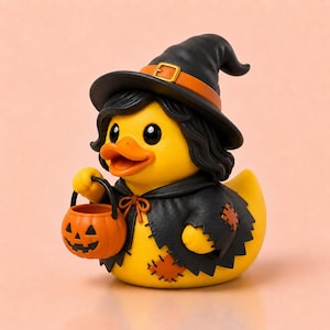 Pode incluir: Um pato de borracha amarelo vestido de bruxo, usando um chapéu pontudo preto com uma faixa laranja e uma capa preta com remendos laranja. O pato tem cabelo preto e segura um pequeno balde de abóbora laranja com um rosto esculpido.