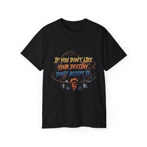 May include: Black t-shirt with the quote "If you don't like your destiny don't accept it" in orange, blue, and yellow. The shirt features a stylized design with stars and a flame-like emblem.