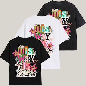 Puede incluir: Tres camisetas de gran tamaño en negro, blanco y gris carbón. Cada camiseta presenta el texto "His Way Is Better" en un diseño colorido y en capas con estrellas, estampado de leopardo y una cruz. Las camisetas tienen mangas cortas y un corte holgado.