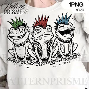 May include: White sweatshirt featuring a graphic of three punk rock frogs with mohawk hairstyles in green, red, and blue. The frogs have piercings, leather jackets, and studded collars. The text "Pattern PRISME" is at the top left.