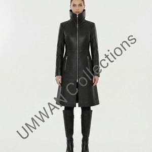 May include: A full-length black leather coat with a high collar and a silver zipper. The coat has long sleeves and two front pockets. The model is wearing black knee-high boots. The text "UMWAN Collections" is visible on the left side of the image.