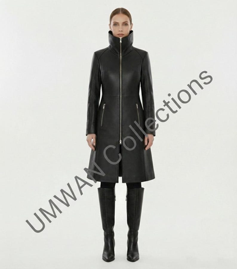 May include: A full-length black leather coat with a high collar and a silver zipper. The coat has long sleeves and two front pockets. The model is wearing black knee-high boots. The text "UMWAN Collections" is visible on the left side of the image.