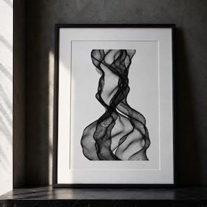Peut inclure: Une impression d'art mural encadrée présentant un motif abstrait en noir et blanc composé de lignes fluides et complexes qui créent une sensation de mouvement et de profondeur, le tout dans un passe-partout blanc et un cadre noir fin.