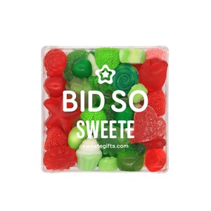 May include: A clear rectangular container filled with assorted red and green gummy candies. The candies include hearts, stars, and other shapes. The text "BID SO SWEEETE" and "sweetegifts.com" are printed on the container.