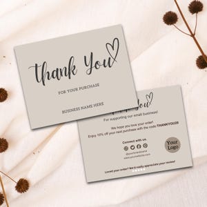 May include: Two beige thank you cards with black script. The top card says "Thank You" with a heart, "For Your Purchase," and "Business Name Here." The second card has additional text, including "Thank You," a heart, and a logo.