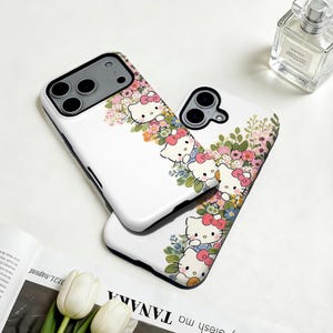 Puede incluir: Dos fundas blancas para tel&eacute;fono con un dise&ntilde;o floral y Hello Kitty. Las fundas presentan un patr&oacute;n repetido del ic&oacute;nico personaje de dibujos animados con lazos rosas, rodeado de flores coloridas y hojas verdes. Las fundas son para un tel&eacute;fono inteligente.