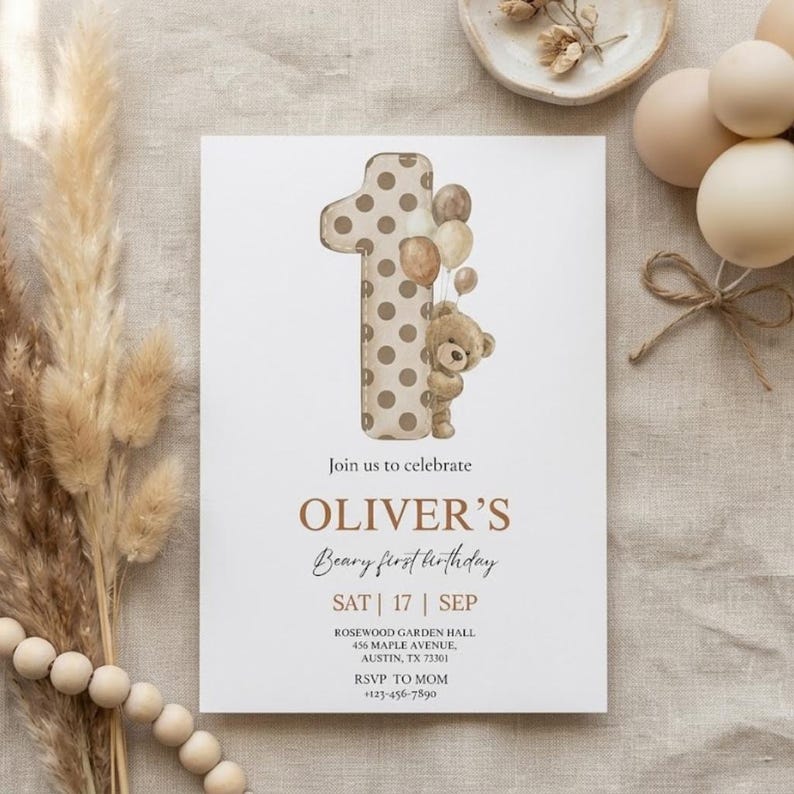 Pode incluir: Um cart&atilde;o de convite branco com o texto "Join us to celebrate OLIVER'S Beary first birthday". O n&uacute;mero um &eacute; decorado com bolinhas marrons e um ursinho de pel&uacute;cia segurando bal&otilde;es. O texto adicional inclui a data, o local e as informa&ccedil;&otilde;es RSVP.