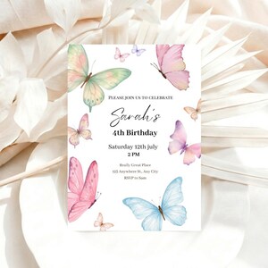 K&ouml;nnte beinhalten: Eine wei&szlig;e Geburtstagseinladung mit Aquarell-Schmetterlingen in Rosa, Blau und Gr&uuml;n. Der Text lautet: "Please join us to celebrate Sarah's 4th Birthday, Saturday 12th July 2 PM".