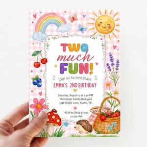 Op de afbeelding: Een rechthoekige verjaardagsuitnodiging met een roze gingham achtergrond, voorzien van aquarelillustraties van een regenboog, zon, kersen, bosbessen, bloemen, een paddenstoel, een egel en een picknickmand met de tekst TWO MUCH FUN!