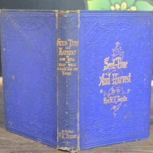 May include: A blue book with gold lettering on the cover. The title is "Seed Time and Harvest Sow Well Reap Well A Book for the Young".
