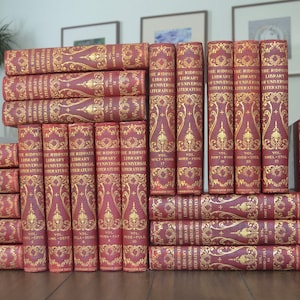 May include: A set of 30 antique books with red leather covers and gold lettering. The books are titled "The Wisdom Library of Universal Literature".