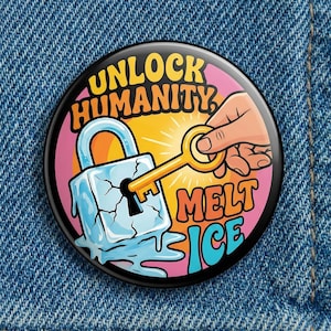 May include: Round button with the text "UNLOCK HUMANITY MELT ICE". The design features a hand holding a gold key unlocking a padlock made of ice. The background has a pink and yellow burst.