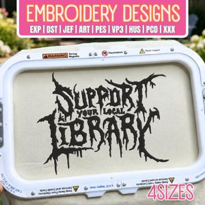 Puede incluir: Un bastidor de bordado blanco con tela color crema y texto bordado a máquina en negro que dice SUPPORT YOUR LOCAL LIBRARY en una fuente irregular y goteante. El marco del bastidor incluye etiquetas de advertencia y herrajes.