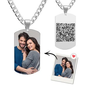 May include: Two silver dog tag necklaces with chain links. One tag displays a couple's photo, the other a QR code. A small photo of the couple with a heart icon is also shown.