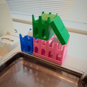 Op de afbeelding: Een witte keramische mok met een zwarte handgreep en de tekst "But First, Coffee" in een vetgedrukte, zwarte letter. De mok staat tegen een vage achtergrond, wat het strakke ontwerp benadrukt.