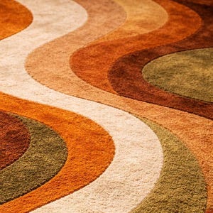 May include: Close-up of a retro-style rug with a wavy pattern. The rug features bands of color in shades of orange, brown, beige, and olive green. The texture appears plush and soft, with a vintage aesthetic.