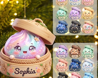 May include: A hanging ornament featuring a cute, iridescent dumpling character with large eyes inside a bamboo steamer basket. The base of the basket is decorated with floral accents and the name Sophia printed in a dark script font on a plaque.