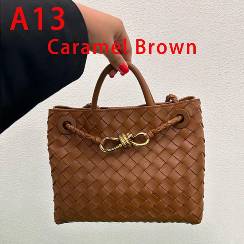 K&ouml;nnte beinhalten: Karamellbraune, gewebte Handtasche mit goldfarbenem Verschluss. Die Tasche hat zwei Henkel und einen geflochtenen Riemen. Der Text "A13 Caramel Brown" ist im Bild zu sehen.