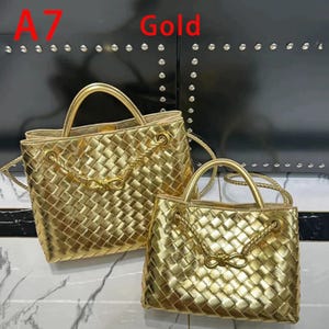 K&ouml;nnte beinhalten: Zwei goldene, gewebte Handtaschen mit oberen Griffen und Kettendetails. Die Taschen haben eine quadratische Form und einen geflochtenen Akzent auf der Vorderseite. Das Wort "Gold" steht rot oben im Bild.
