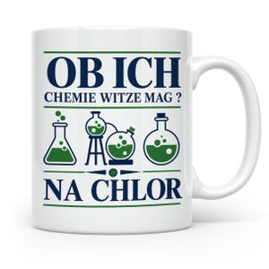 Könnte beinhalten: Ein weißer Keramikbecher mit dunkelblauem Text, der OB ICH CHEMIE WITZE MAG? NA CHLOR lautet. Das Design enthält vier grüne und dunkelblaue Illustrationen von Laborgeräten, darunter Bechergläser und Kolben, die zwischen den Textzeilen angeordnet sind.