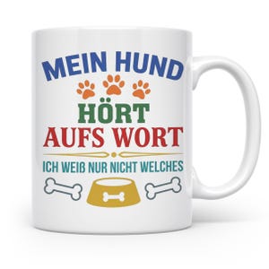 Könnte beinhalten: Ein weißer Keramikbecher mit dem deutschen Text MEIN HUND HÖRT AUFS WORT ICH WEIB NUR NICHT WELCHES in Blau, Grün und Rot. Das Design enthält drei orangefarbene Pfotenabdrücke, einen gelben Hundenapf mit Knochen-Symbol und zwei graue Knochen.