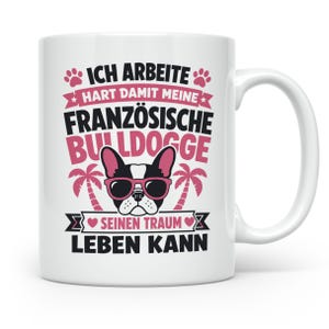 Könnte beinhalten: Eine weiße Keramiktasse mit einer Grafik einer Französischen Bulldogge mit rosa Sonnenbrille. Der Text lautet: ICH ARBEITE HART DAMIT MEINE FRANZÖSISCHE BULLDOGGE SEINEN TRAUM LEBEN KANN, verziert mit rosa Pfotenabdrücken und Palmen.