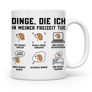 Könnte beinhalten: Ein weißer Keramikbecher mit dem schwarzen Text "DINGE, DIE ICH IN MEINER FREIZEIT TUE" oben. Darunter zeigen sechs Illustrationen Aktivitäten rund um den Beagle mit deutschen Bildunterschriften, darunter Spielen, Videos schauen, recherchieren, reden, denken und von Beagles träumen.