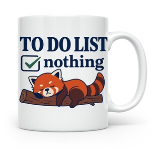 Könnte beinhalten: Ein weißer Keramikbecher mit einer Grafik eines schlafenden roten Pandas, der auf einem braunen Ast liegt. Über dem Panda steht der Text TO DO LIST mit einem Kontrollkästchen, das einen grünen Haken neben dem Wort nothing in Dunkelblau zeigt.