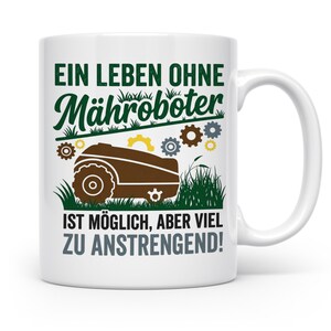 Könnte beinhalten: Ein weißer Keramikbecher mit einer Grafik eines braunen Mähroboters, umgeben von kleinen bunten Zahnrädern und grünem Gras. Der Text lautet: EIN LEBEN OHNE Mähroboter IST MÖGLICH, ABER VIEL ZU ANSTRENGEND! Das Design ist in Dunkelgrün, Braun und Grau gedruckt.