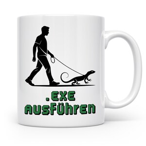 Könnte beinhalten: Weiße Keramiktasse mit einer schwarzen Silhouette einer Person, die eine Eidechse an der Leine führt. Unter dem Bild steht der Text ".EXE AUSFÜHREN" in grünen Blockbuchstaben. Die Tasse hat einen weißen Henkel.