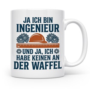 Könnte beinhalten: Ein weißer Keramikbecher mit dunkelblauem Text, der JA ICH BIN INGENIEUR UND JA, ICH HABE KEINEN AN DER WAFFEL lautet. Das Design zeigt einen braunen Schutzhelm, graue Zahnräder und ein orangefarbenes Lineal mit der Aufschrift CM.